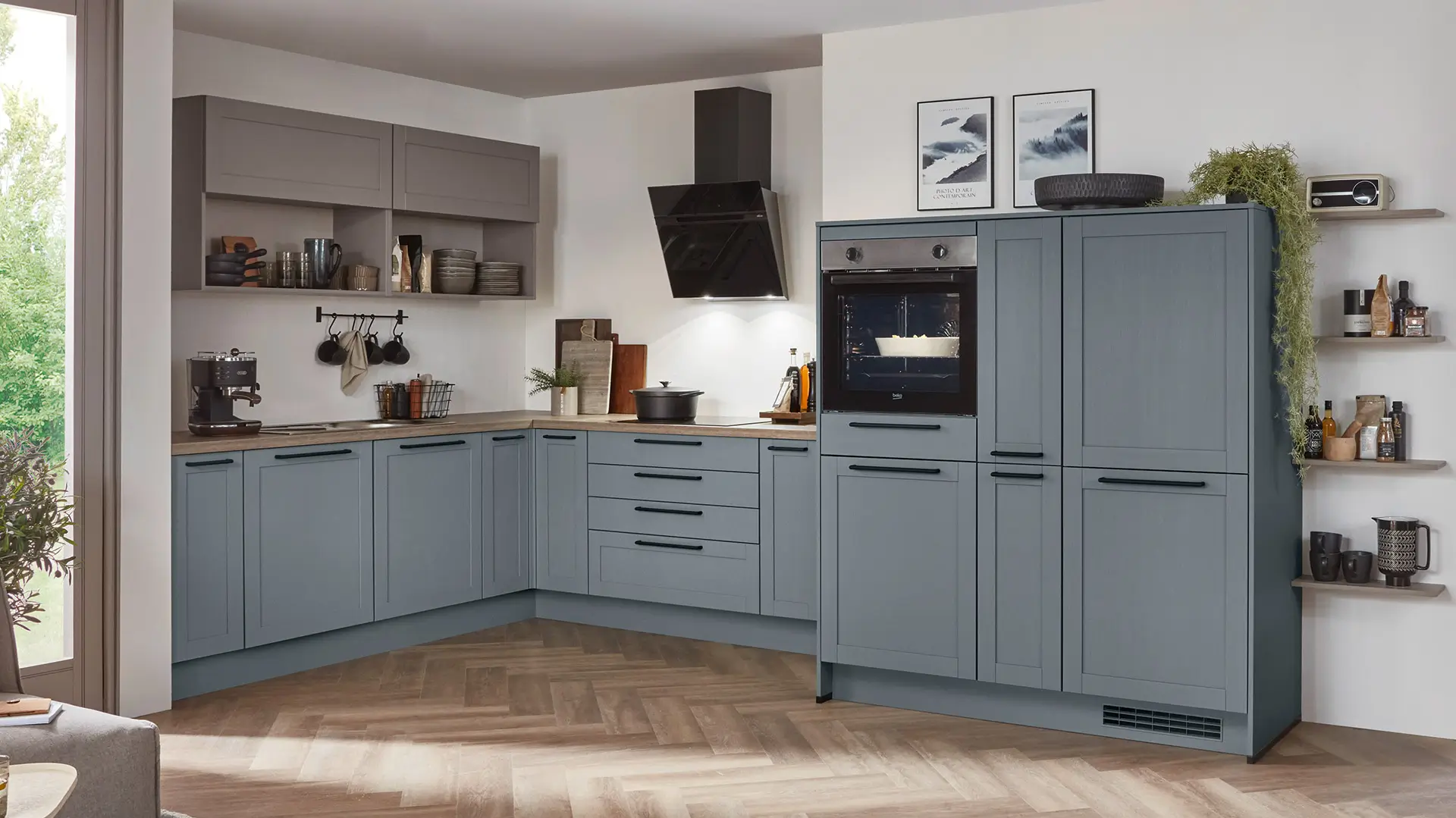 Moderne L-förmige Küche mit blauen Unterschränken, grauen Oberschränken und eingebautem Ofen.